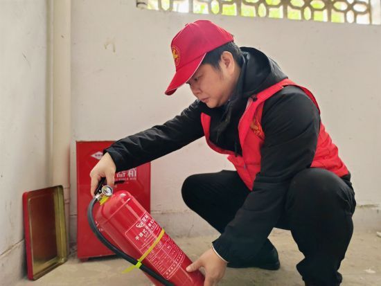 圖為志愿者協(xié)助社區(qū)檢查消防設施