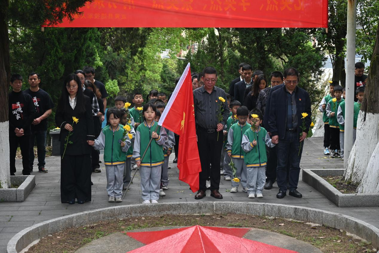 圖為志愿者們向革命烈士紀(jì)念碑默哀.png