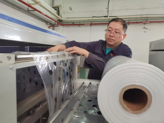 圖為分揀班長(zhǎng)在更換打孔膜