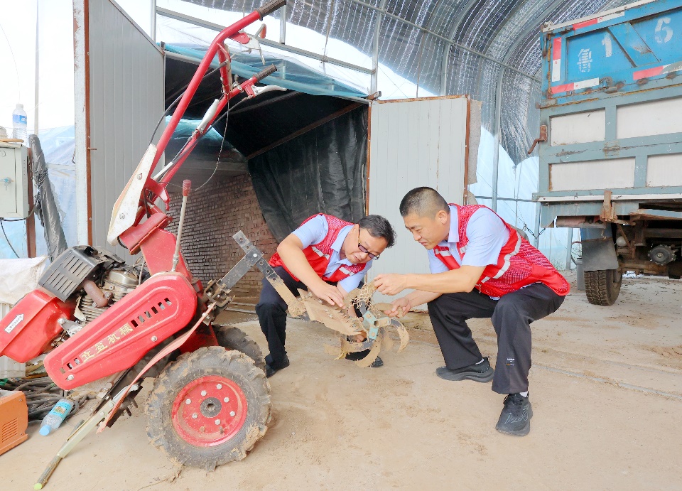 圖為志愿者們更換農(nóng)機(jī)配件