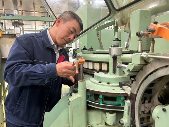 圖為該廠卷包車間副主任技師黃昕利用轉(zhuǎn)班時(shí)間調(diào)試設(shè)備