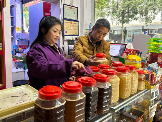 圖為店主張歐祥在整理店鋪內(nèi)柜臺.png