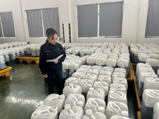 圖為倉庫管理員員正在核對香精數(shù)量