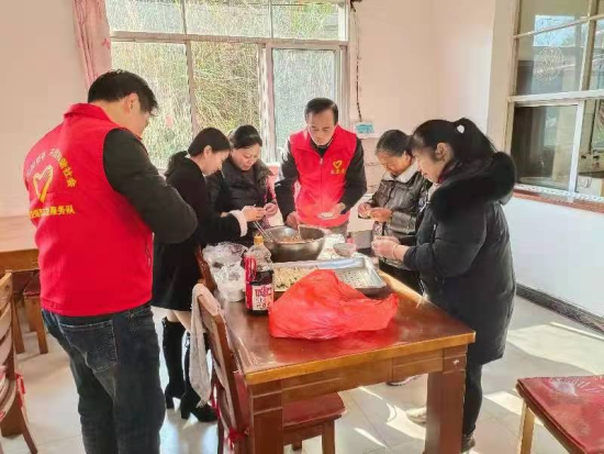 圖為志愿者為老人包餃子