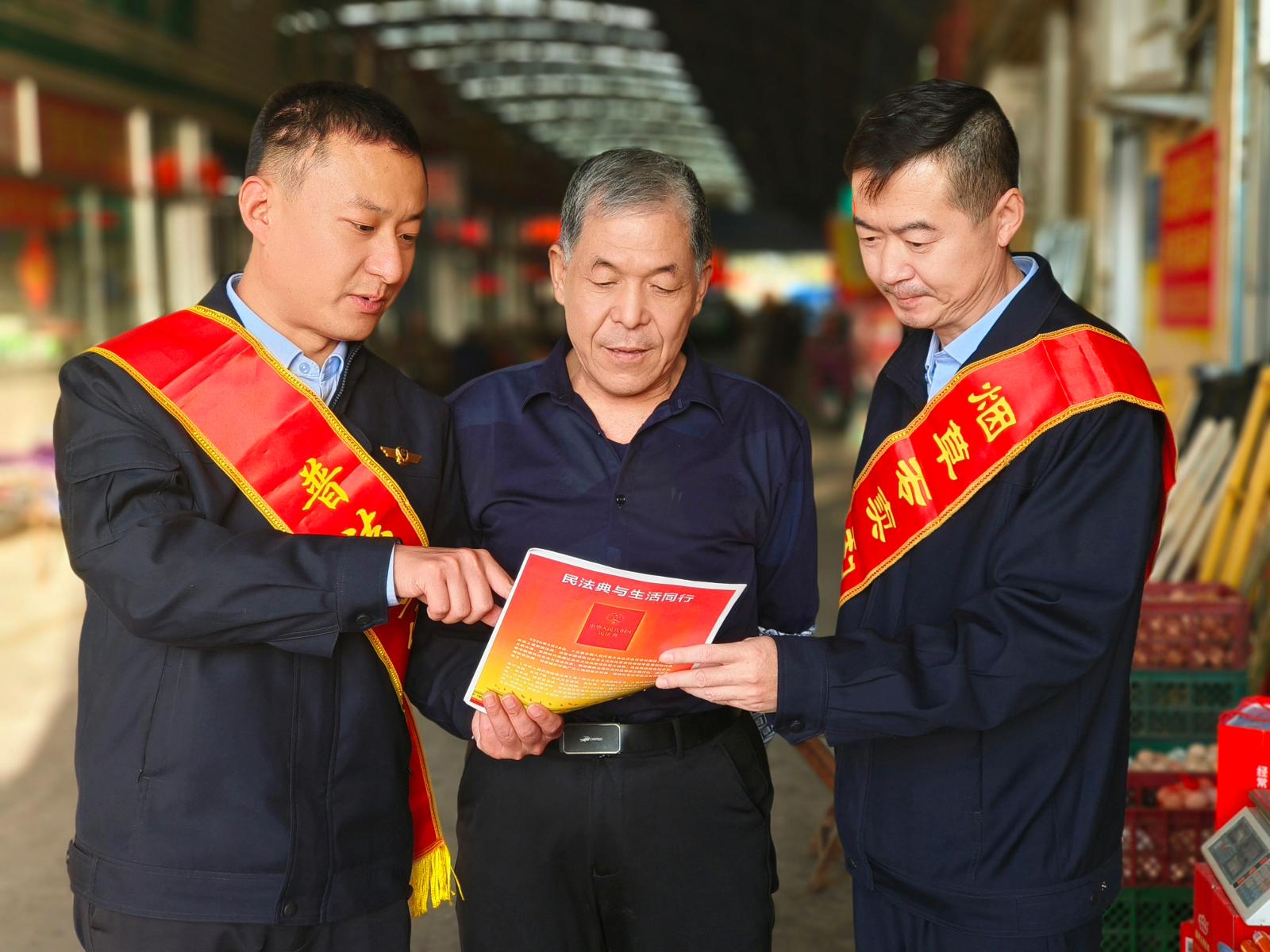 圖為執(zhí)法人員到集貿市場講解法規(guī)政策