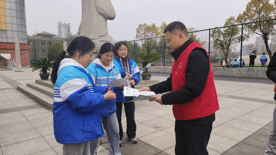 圖為普法志愿者向同學們發(fā)放法律宣傳手冊