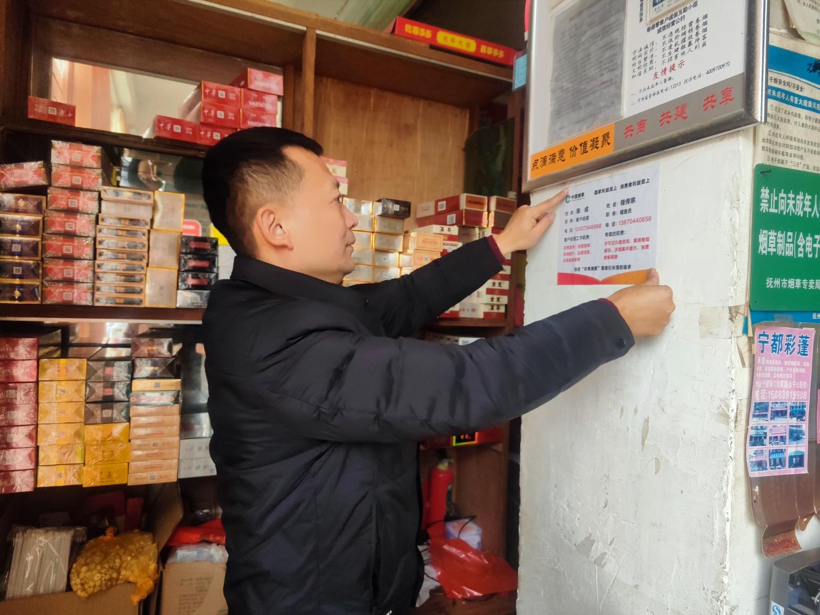 圖為客戶經(jīng)理在農(nóng)網(wǎng)客戶店內(nèi)張貼服務(wù)聯(lián)系單.jpg