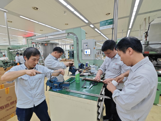 圖為該廠卷包車間維修工對卷煙機易損件進行調(diào)整