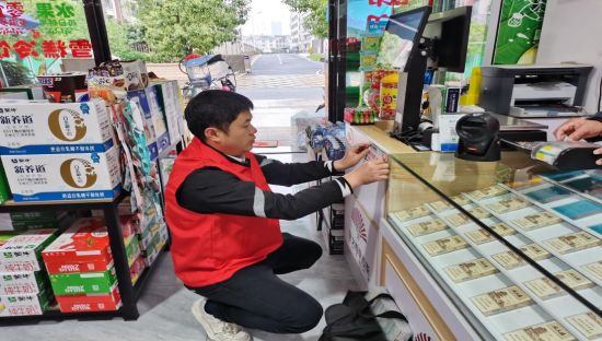 圖為遂川煙草客戶經(jīng)理在零售終端店指導