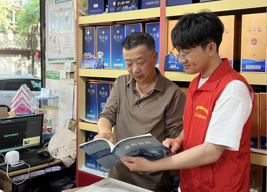 圖為志愿者向零售戶宣傳普法