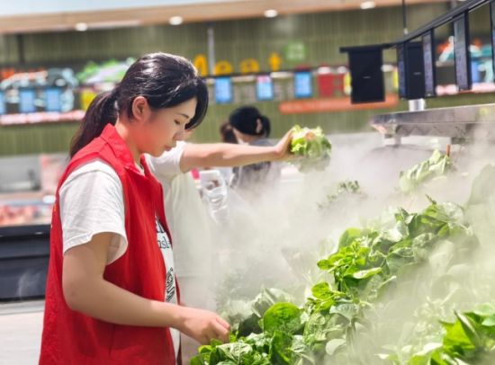 圖為志愿者幫助零售戶整理有機(jī)蔬菜
