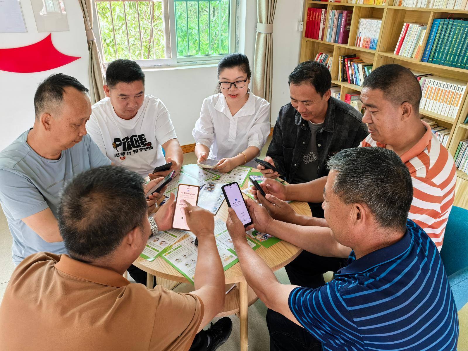 普法隊員正在指導(dǎo)煙點人員下載并使用DeepSeek.jpg