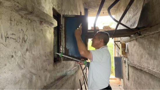 圖為煙技員溫東源正在進行烤房檢修