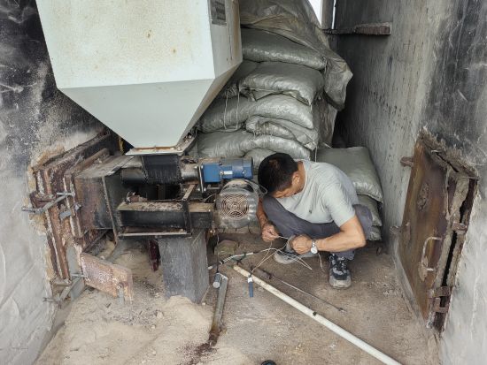 圖為設(shè)備維修人員在維修燃燒機(jī)