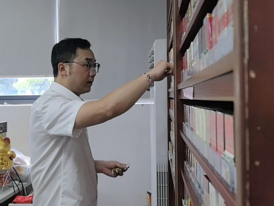 圖為東湖煙草客戶經(jīng)理為客戶整理標(biāo)價(jià)簽