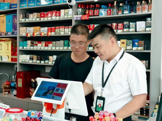 圖為客戶經(jīng)理指導(dǎo)客戶使用智慧終端