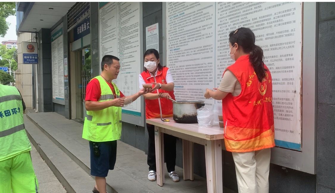 圖為城區(qū)煙草志愿者為環(huán)衛(wèi)工作者送上綠豆湯.jpg