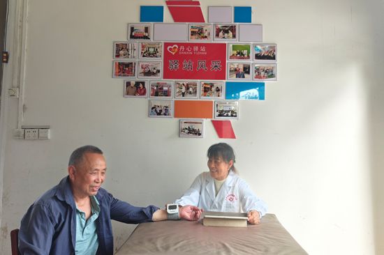 具有村醫(yī)身份的農(nóng)網(wǎng)終端店主粟林弟在為村民測(cè)量血壓 唐俊攝