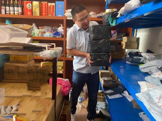 圖為大余縣煙草專賣局客戶經(jīng)理為零售客戶整理便民柜