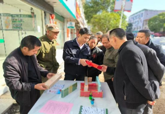 圖為工作人員在集市上向圍觀群眾耐心講解真假鑒別技巧.jpg