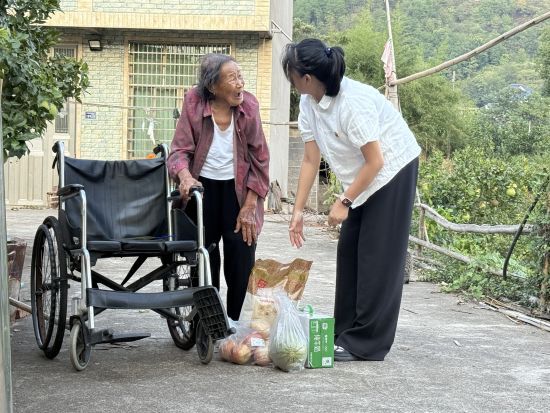 圖為志愿者給黃奶奶帶來生活物資