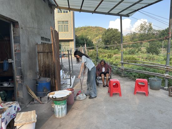 圖為志愿者給黃奶奶帶來生活物資并幫助打掃衛(wèi)生