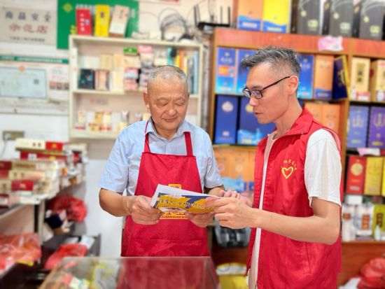 圖為弋陽煙草執(zhí)法人員為老年零售戶進(jìn)行反詐科普.jpg