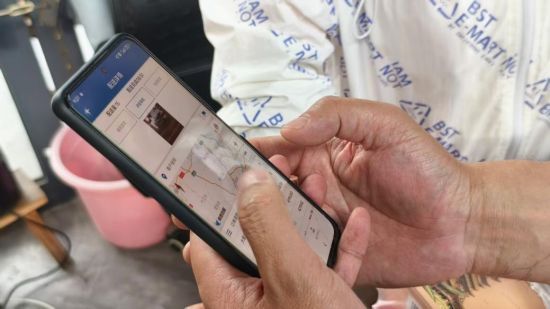 圖為送貨員向客戶介紹智配系統(tǒng)的無紙化簽收