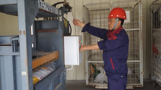 圖為送貨員正在使用壓縮設(shè)備對全市系統(tǒng)回收的熱縮膜進(jìn)行統(tǒng)一打包