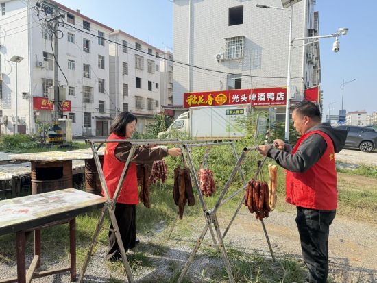 圖為宜豐煙草黨員志愿者幫店主晾曬香腸