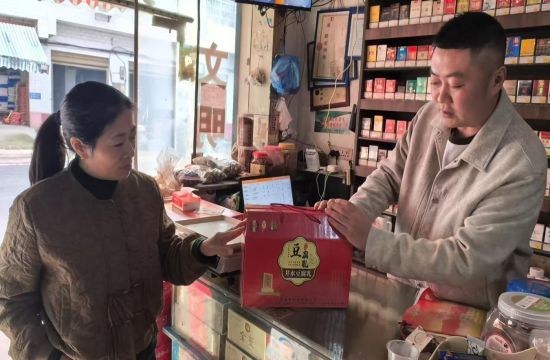 圖為周海初向客戶介紹霉豆腐