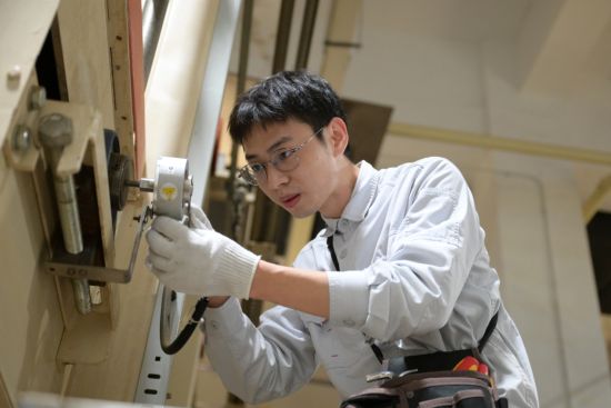 圖為制絲班組人員現(xiàn)場調(diào)整貯絲柜底帶編碼器安裝位置 圖為制絲班組人員現(xiàn)場調(diào)整貯絲柜底帶編碼器安裝位置