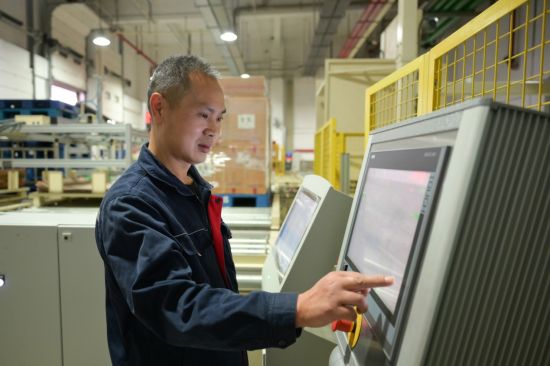 圖為物流班組人員在線調(diào)試成品紙滑托出庫自動翻箱裝置 圖為物流班組人員在線調(diào)試成品紙滑托出庫自動翻箱裝置