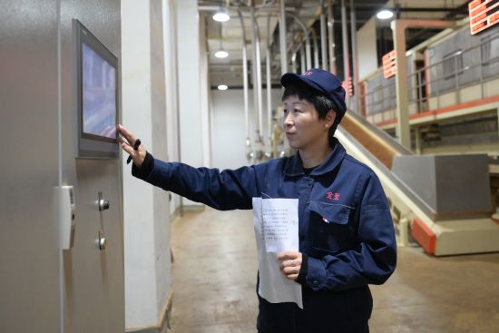 圖為占靜紅在工控電腦前查看機臺煙絲使用數(shù)據(jù)