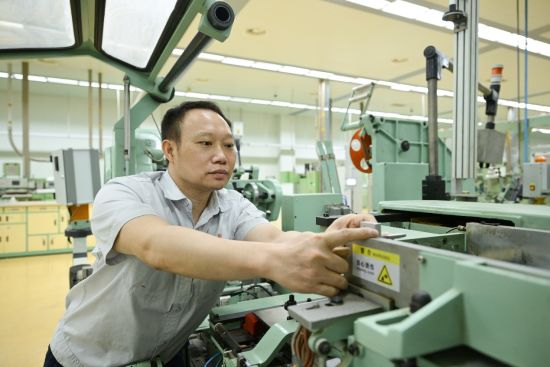 圖為鄭榮猛正在對(duì)機(jī)器設(shè)備進(jìn)行改進(jìn)優(yōu)化 圖為鄭榮猛正在對(duì)機(jī)器設(shè)備進(jìn)行改進(jìn)優(yōu)化