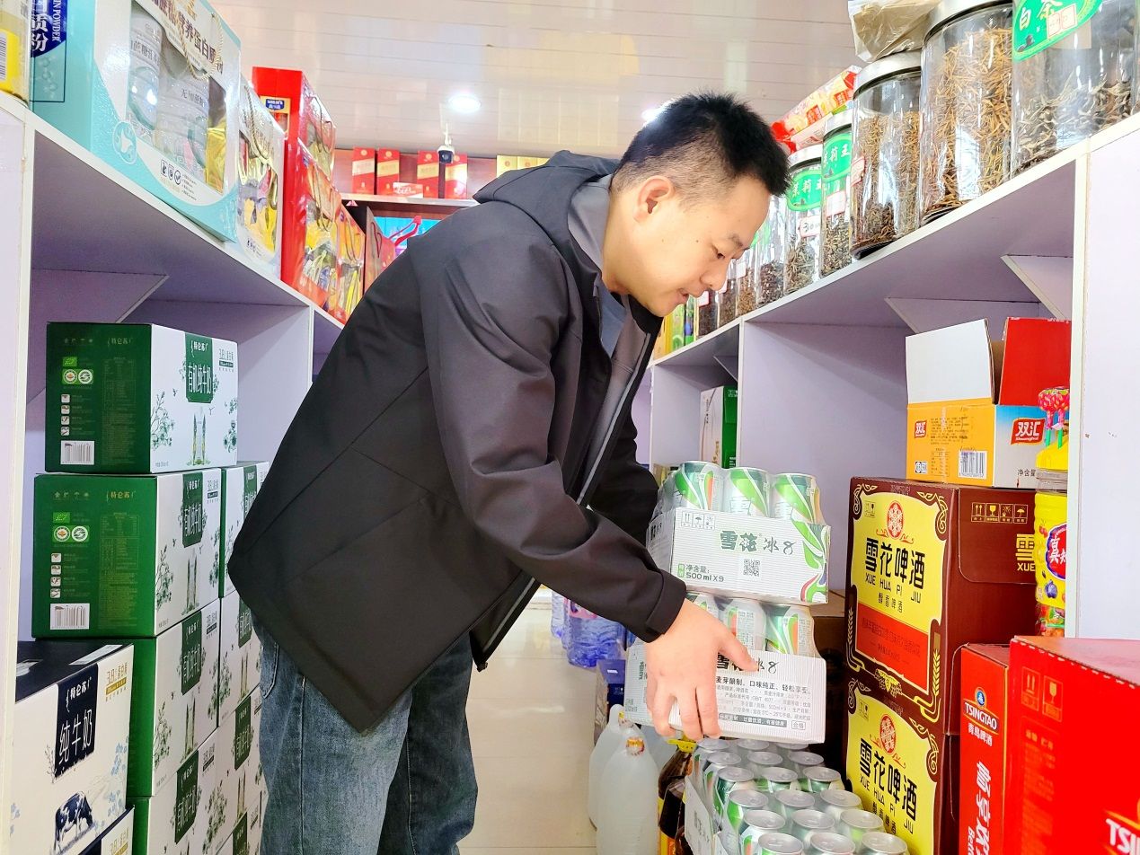 客戶經理劉海濱幫助便民超市整理功能區(qū)