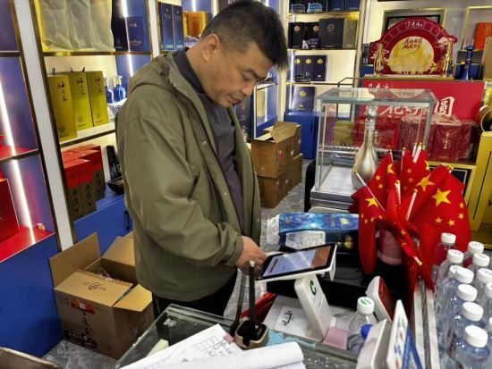 圖為客戶經(jīng)理杜勇查看云pos系統(tǒng)