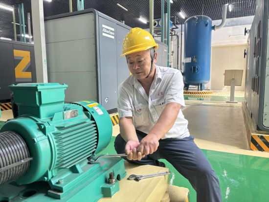 圖為車間維修工正在進行空壓機水泵自主維護工作