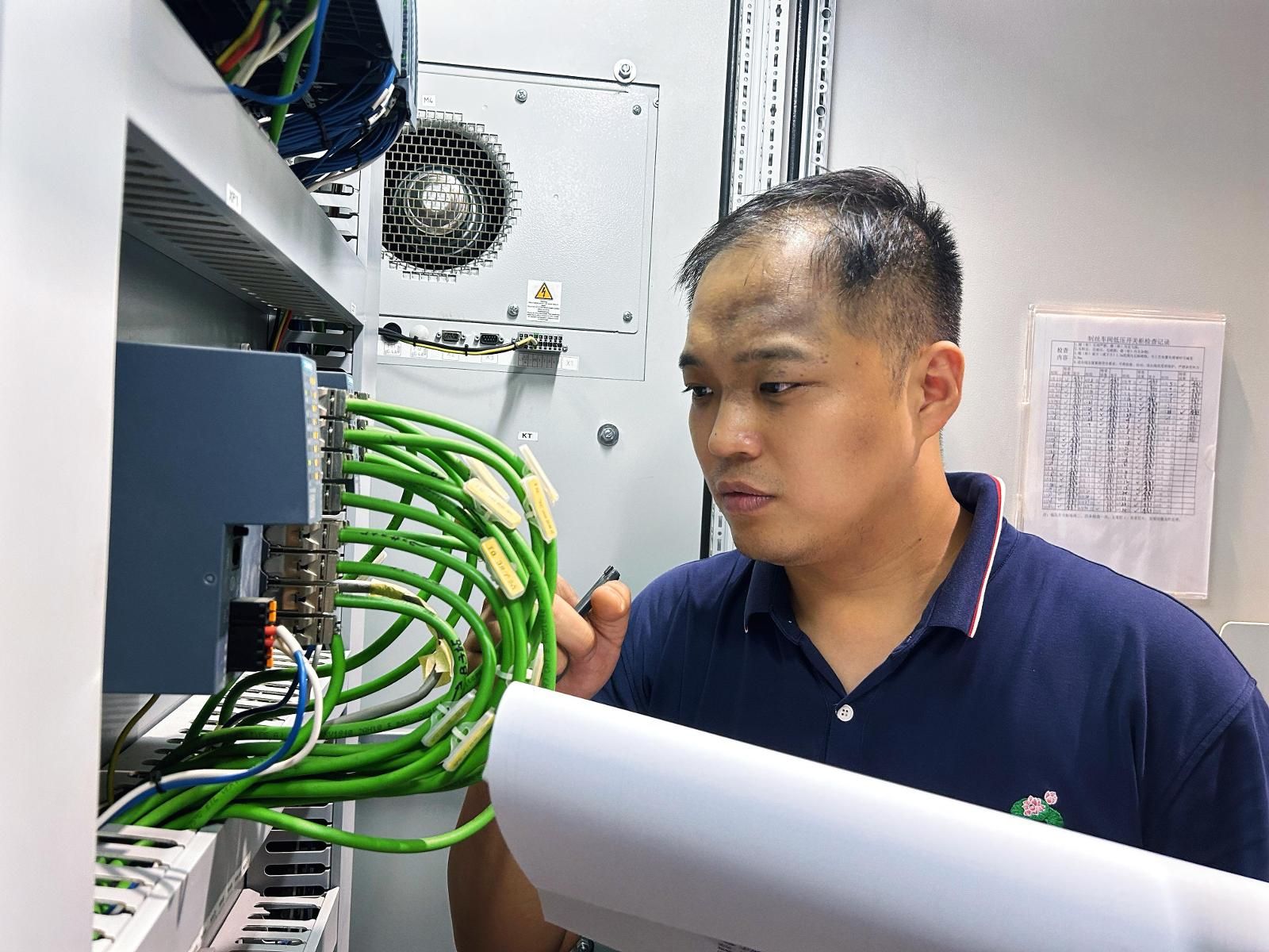 劉雷在車間電控柜檢查網(wǎng)絡(luò)連接線路