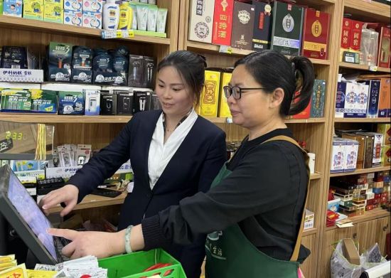 圖為客戶經(jīng)理指導(dǎo)零售戶看終端數(shù)據(jù)報(bào)表