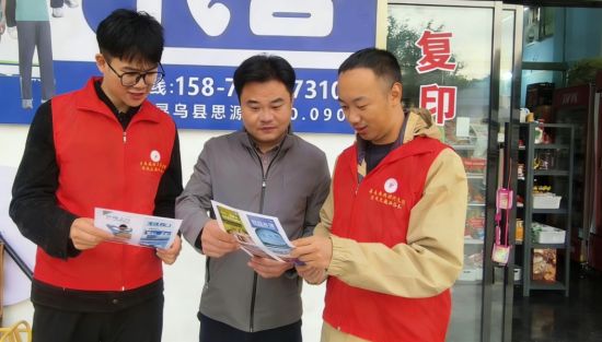 圖為尋烏縣煙草專賣局志愿者為零售戶宣傳禁止向未成年人銷售卷煙