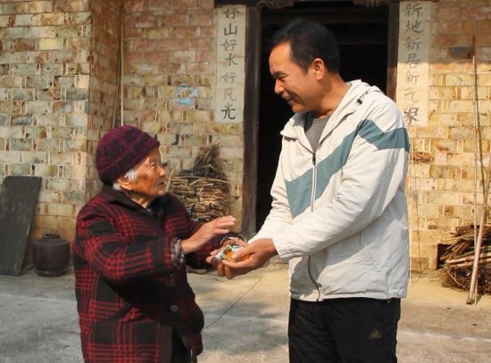 圖為上高煙草駐村第一書記王道玖上門看望百歲老人黃忠娥 陳聰 攝