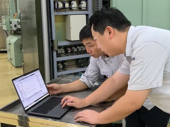 圖為攻關(guān)小組成員在調(diào)試系統(tǒng)參數(shù)