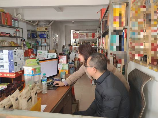 圖為大余縣煙草專賣局客戶經(jīng)理鐘世香指導(dǎo)零售戶使用云POS終端系統(tǒng)