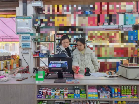 圖為大余縣煙草專賣局客戶經(jīng)理張飛燕指導(dǎo)零售戶進(jìn)行會(huì)員積分操作