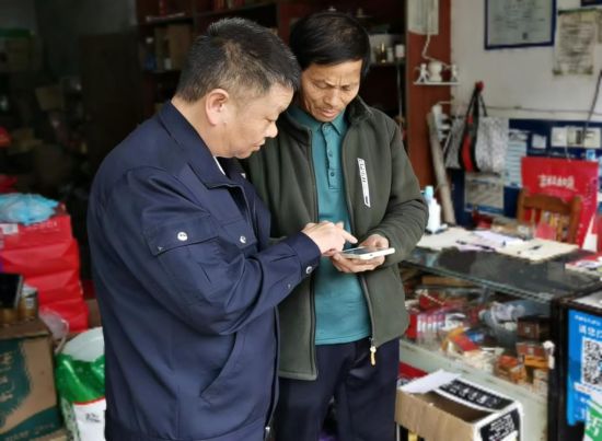 工作人員上門指導零售戶用手機申請