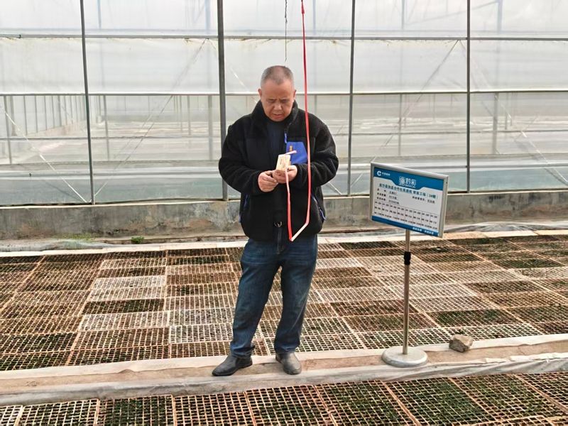 網(wǎng)格管理員龍明財(cái)查看棚內(nèi)溫濕度.jpg
