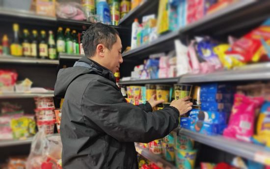 圖為稽查員幫助客戶整理貨架